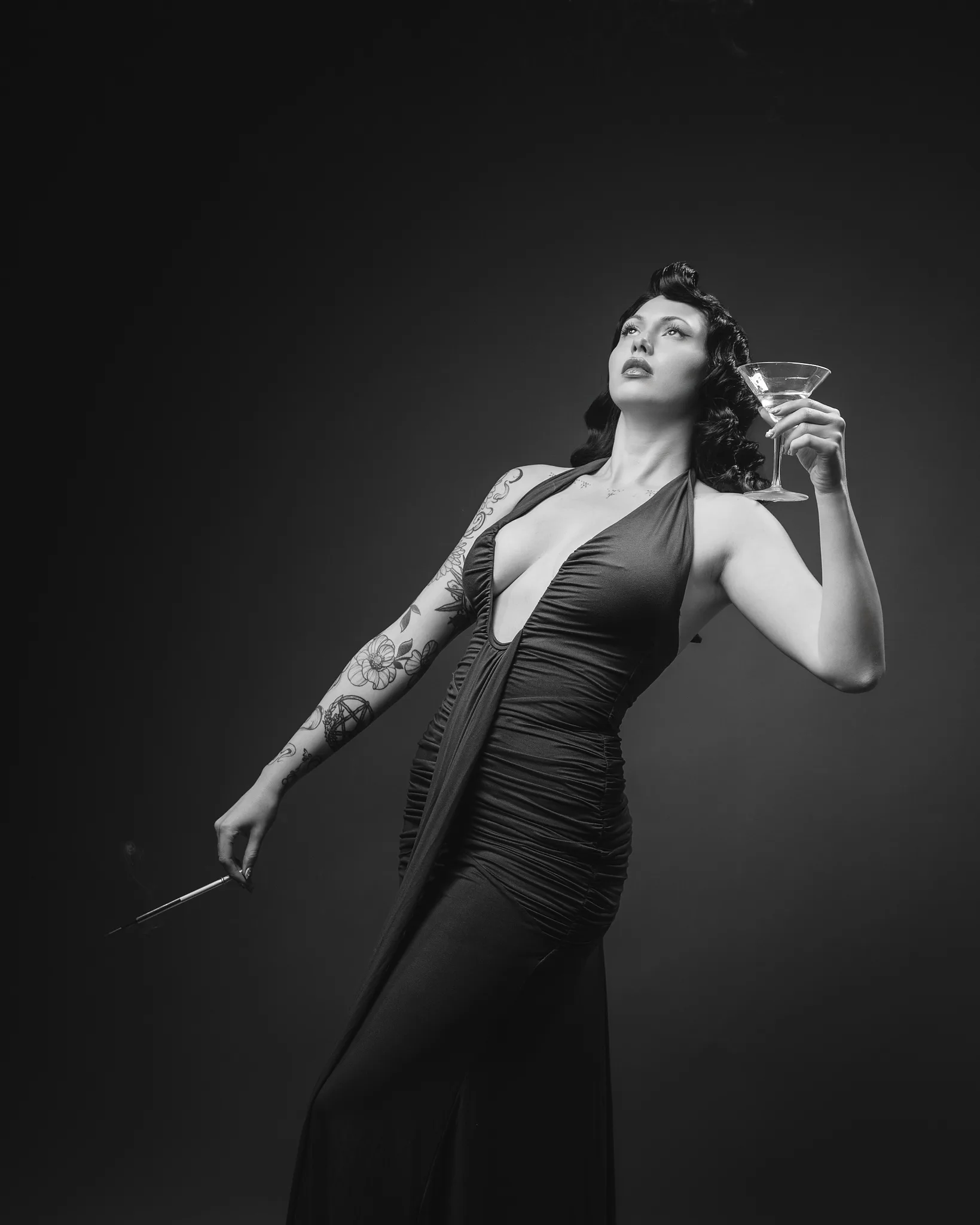 Woman in vintage dress holding cocktail and cigarette