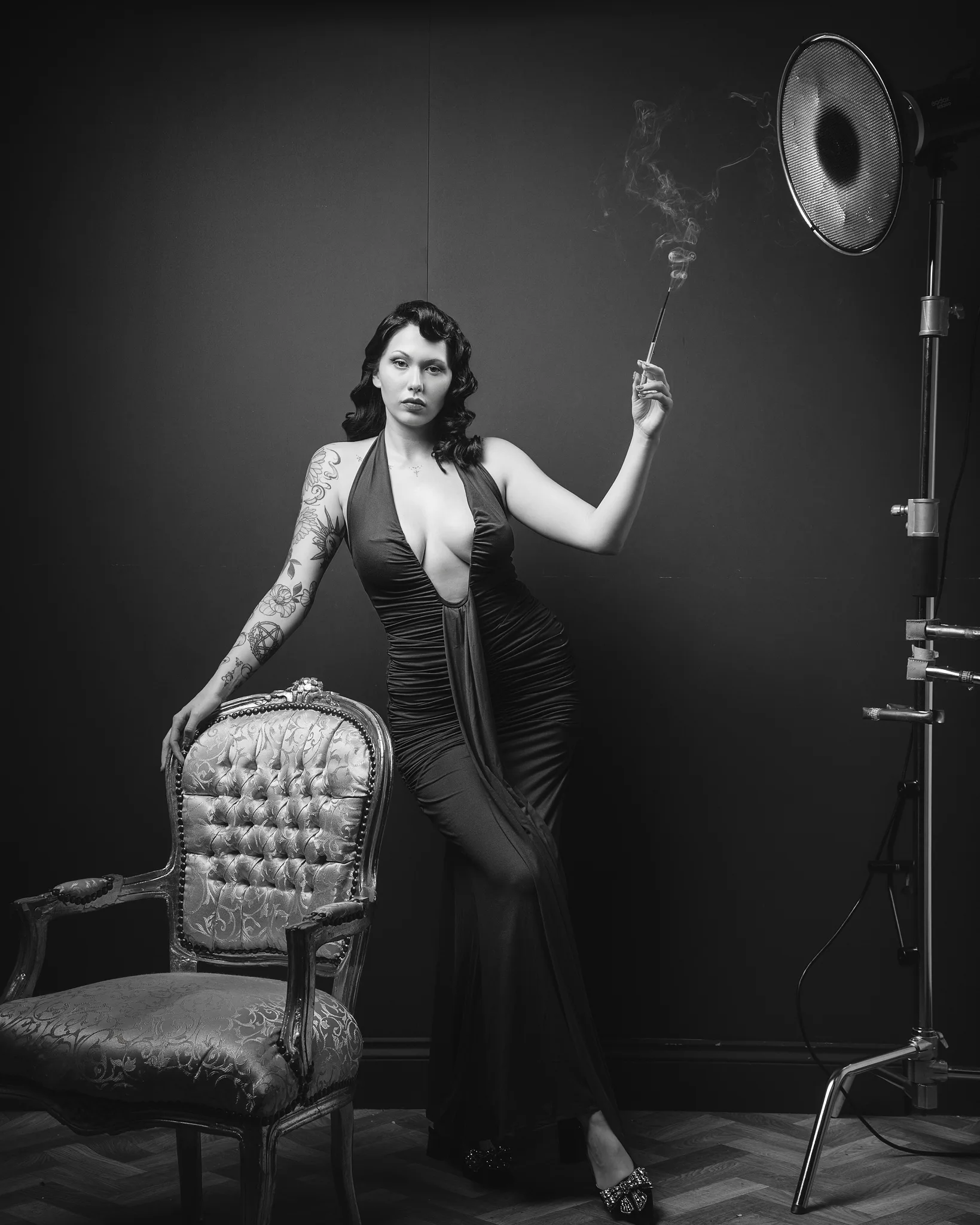 Tattooed woman in black dress with vintage studio lighting setup