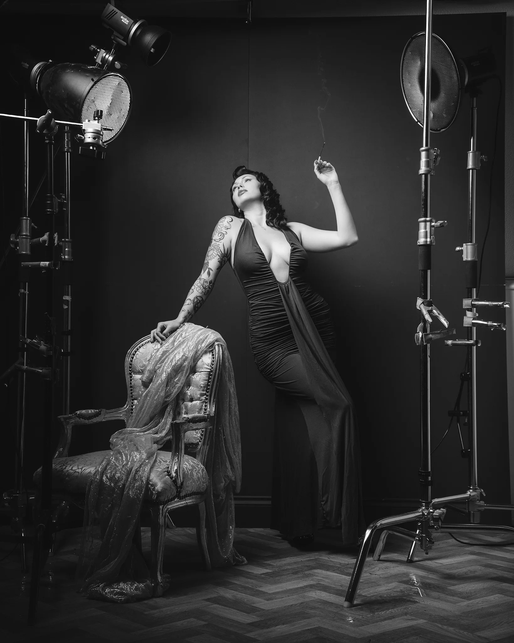 Black and white portrait of tattooed woman in film studio setup