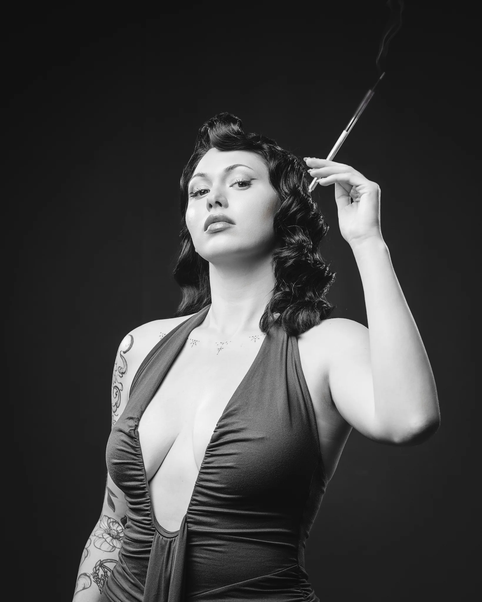 Black and white portrait of woman with vintage waves holding sword