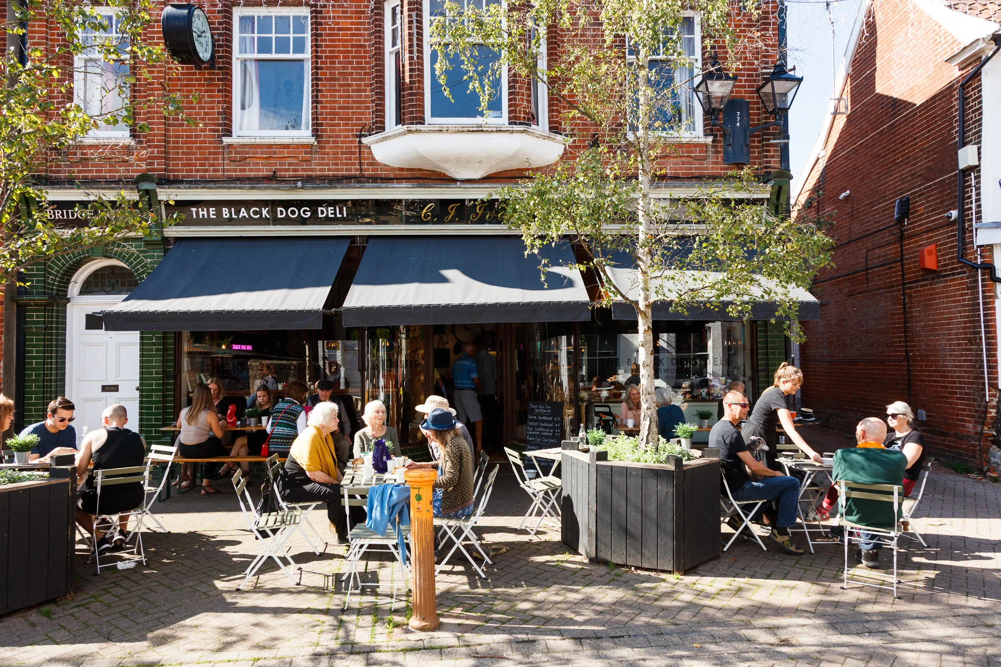 The Black Dog Deli storefront with outdoor seating and customers