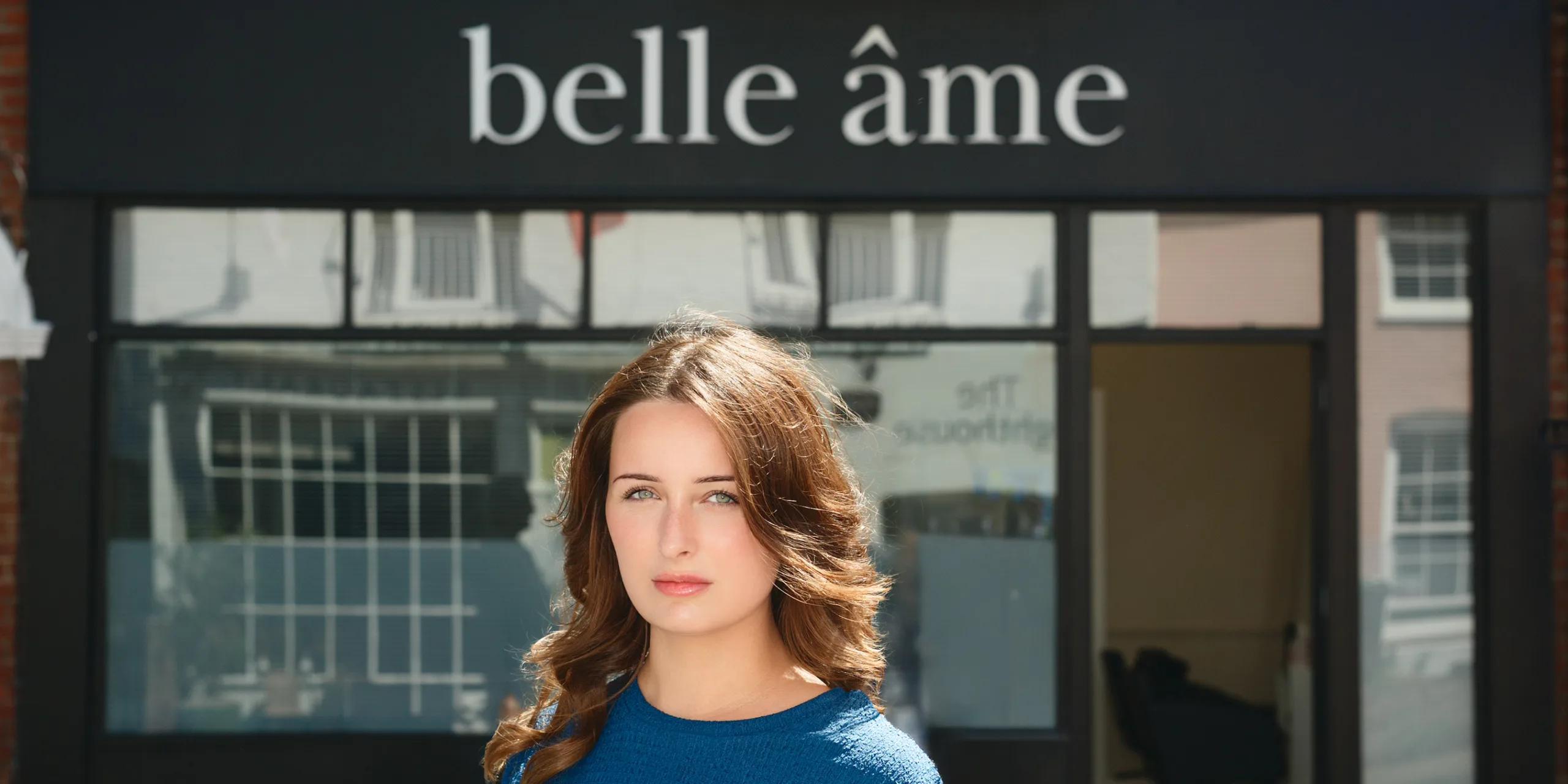 Woman standing outside Belle Âme storefront with signage