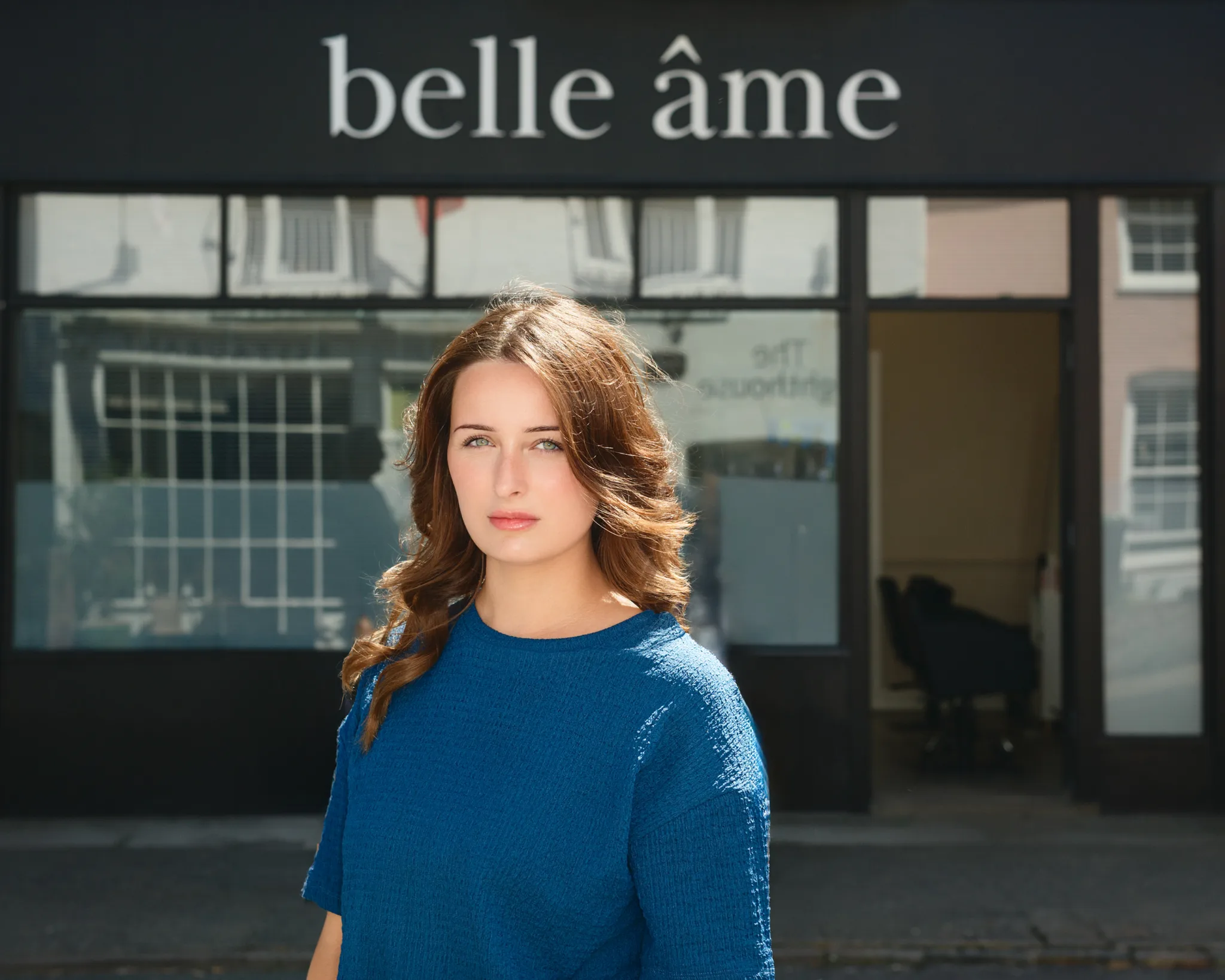 Personal branding photograph of a woman in a blue jumper outside the belle âme shop
