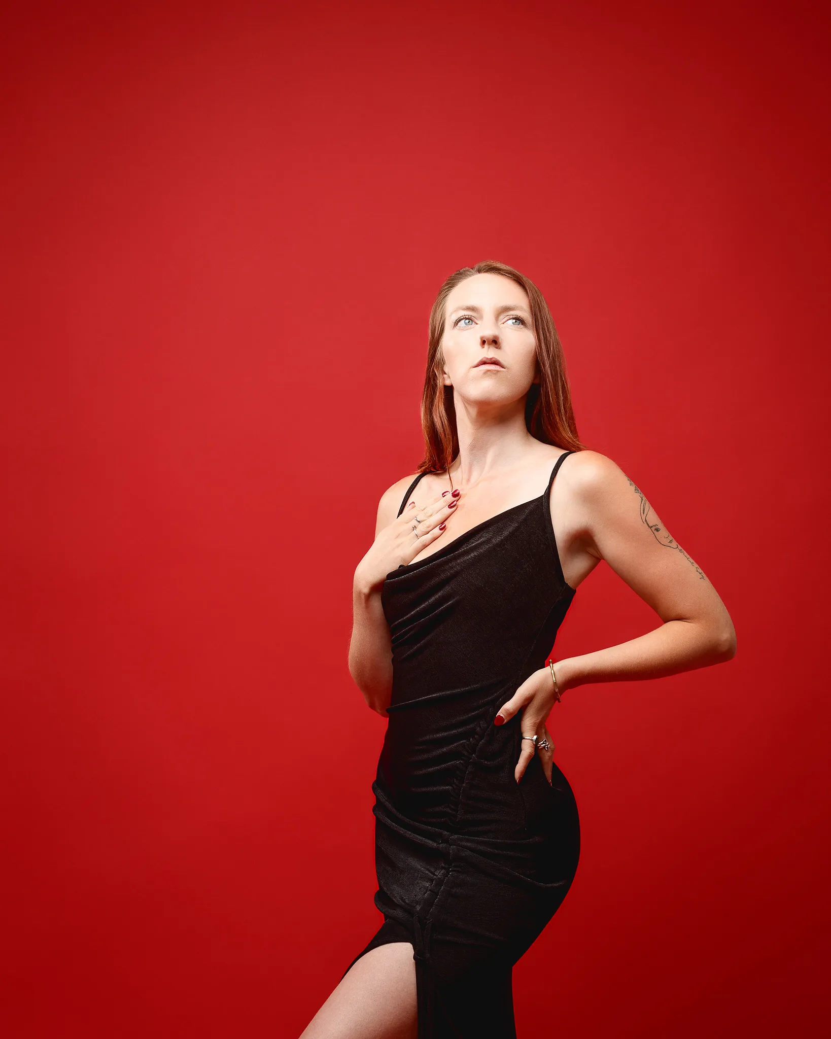 Woman in black dress against vibrant red background