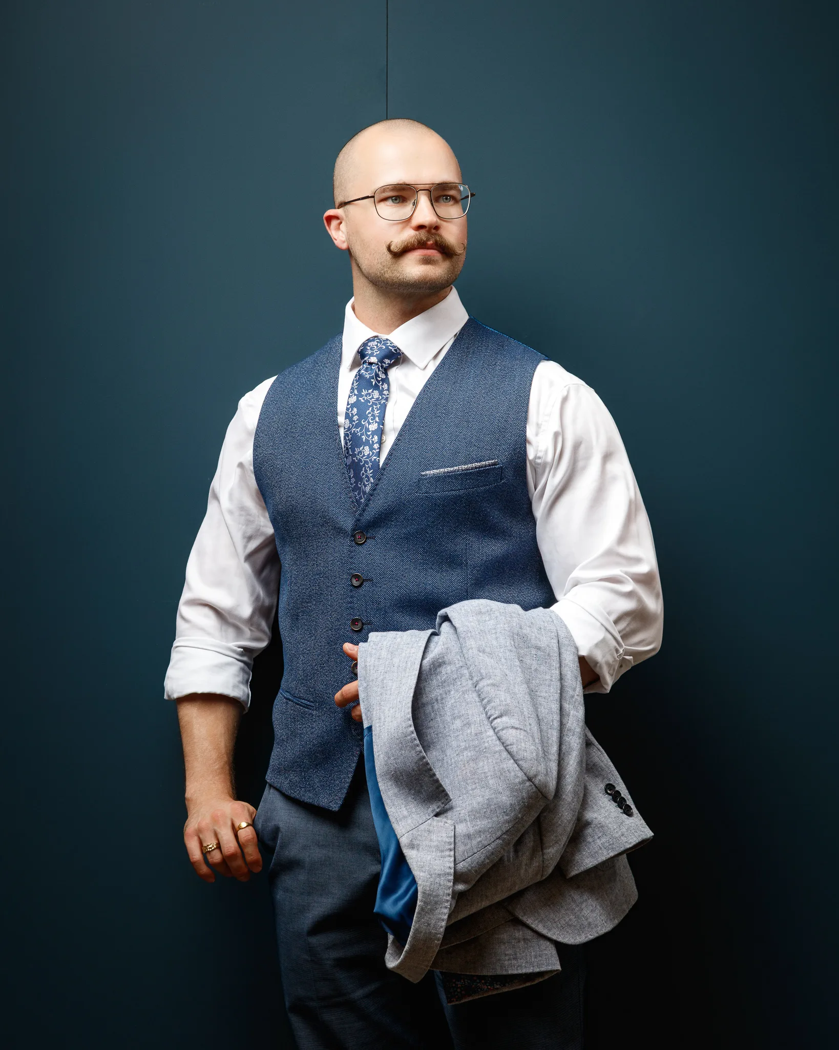 Professional man in waistcoat and glasses against blue background