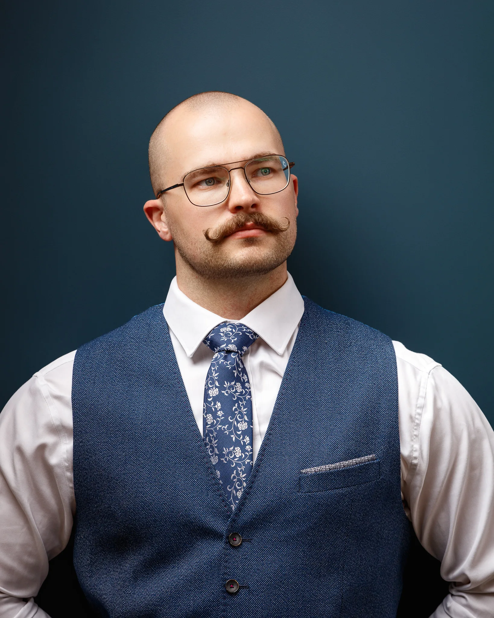 Professional man with distinctive moustache wearing glasses and waistcoat