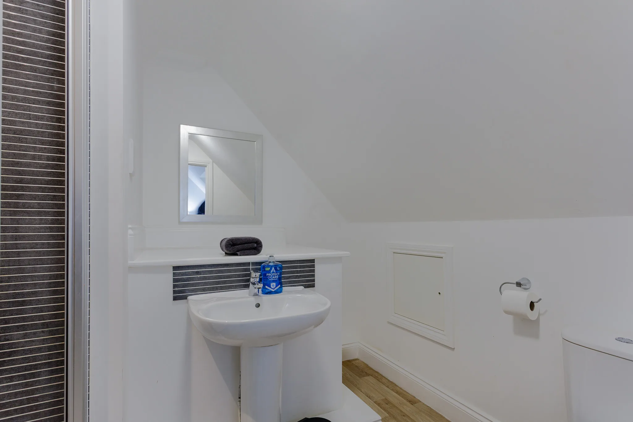 Modern minimalist bathroom with white pedestal sink and mirror