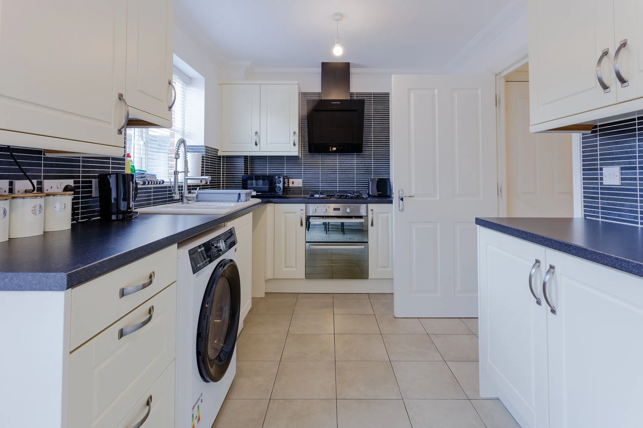 Modern kitchen with white cabinets and blue tile backsplash