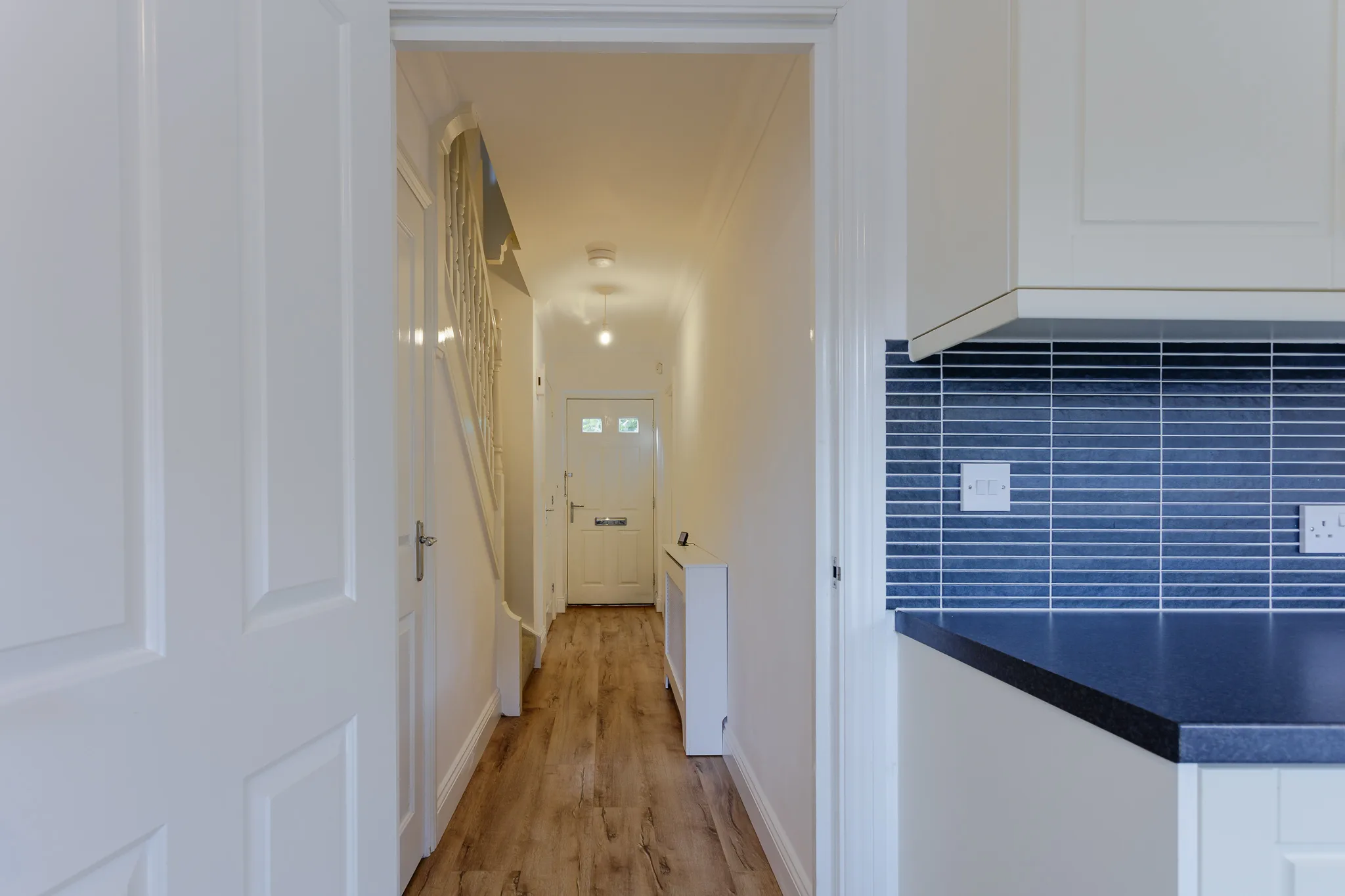 Modern hallway with white doors and wooden flooring