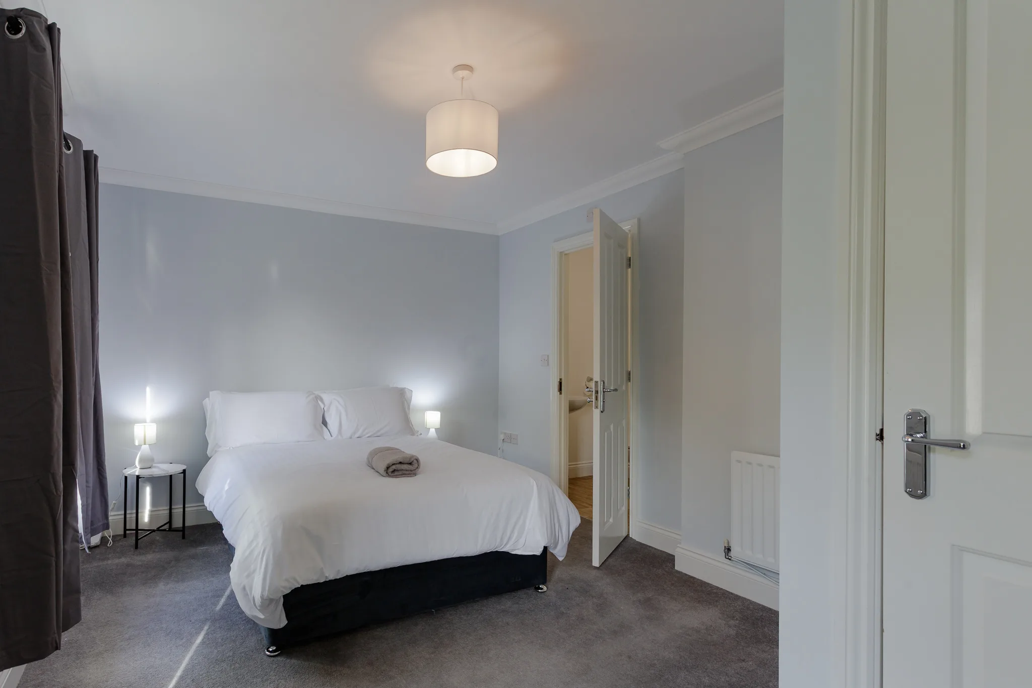 Modern bedroom with white bedding and pendant light fixture