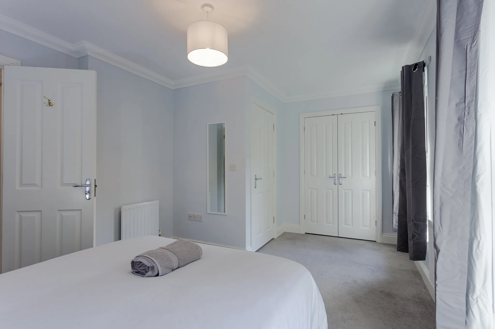Modern white bedroom with double bed and contemporary fixtures