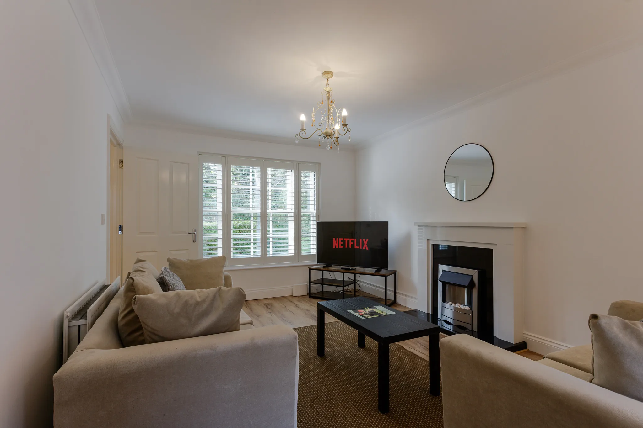 Modern living room with cream sofa, TV, and fireplace