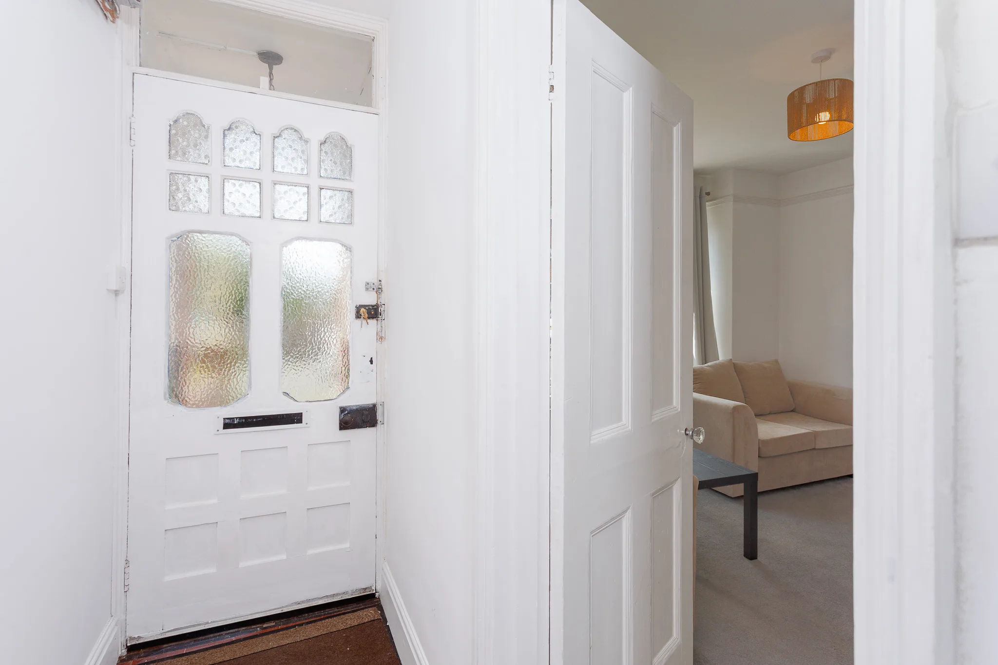 Modern white front door with textured glass panels and hallway view