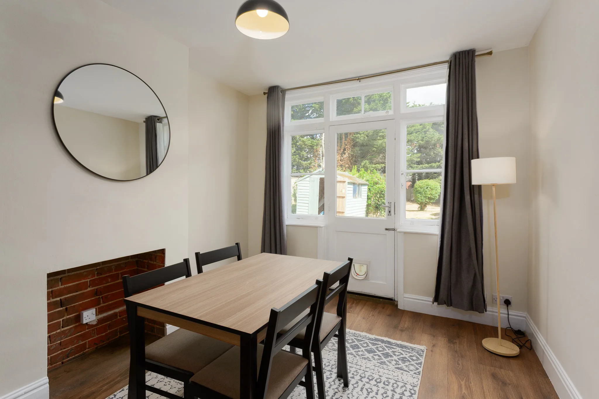 Modern dining room with black table, chairs, and garden views