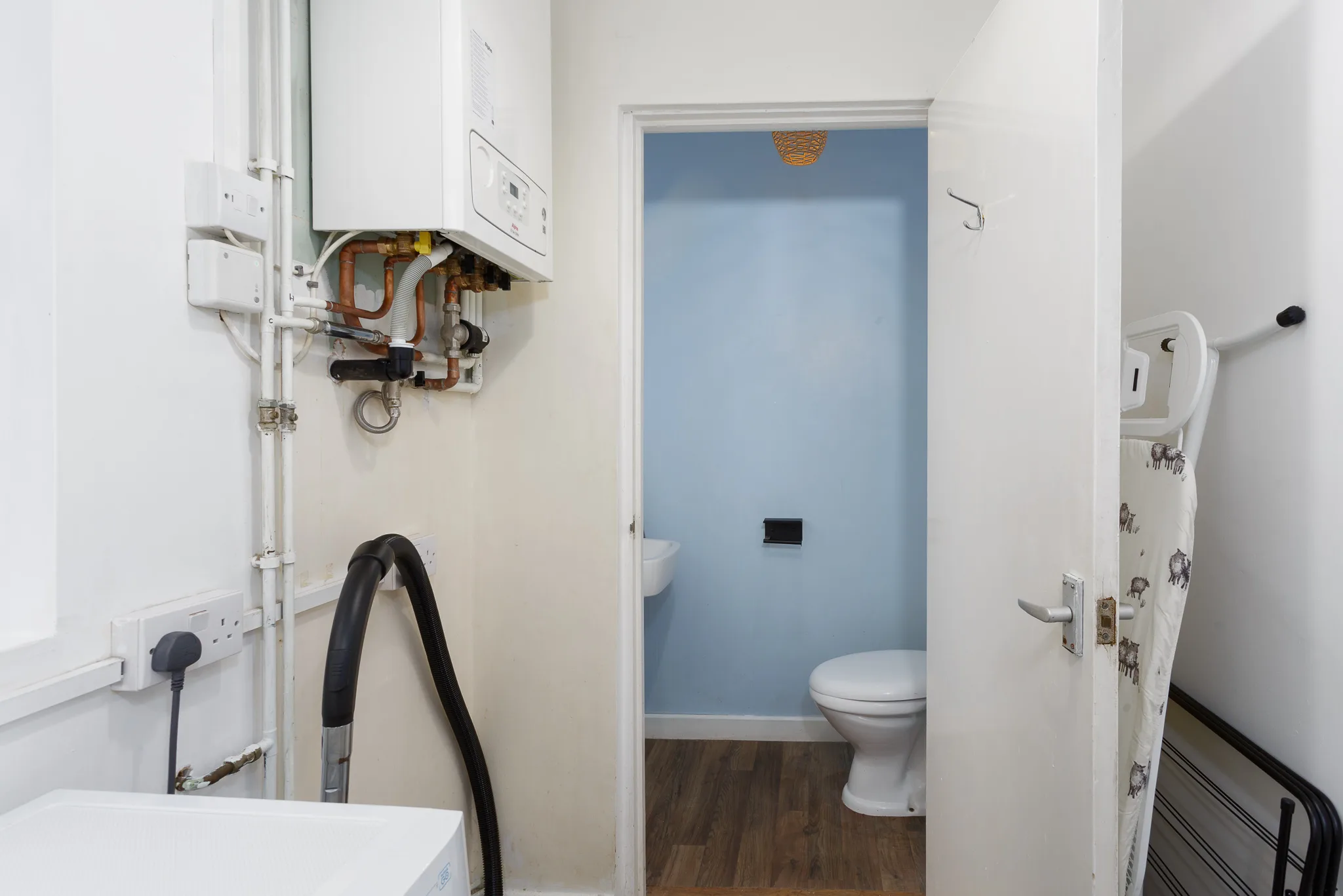 Modern bathroom with boiler, toilet, and blue accent wall