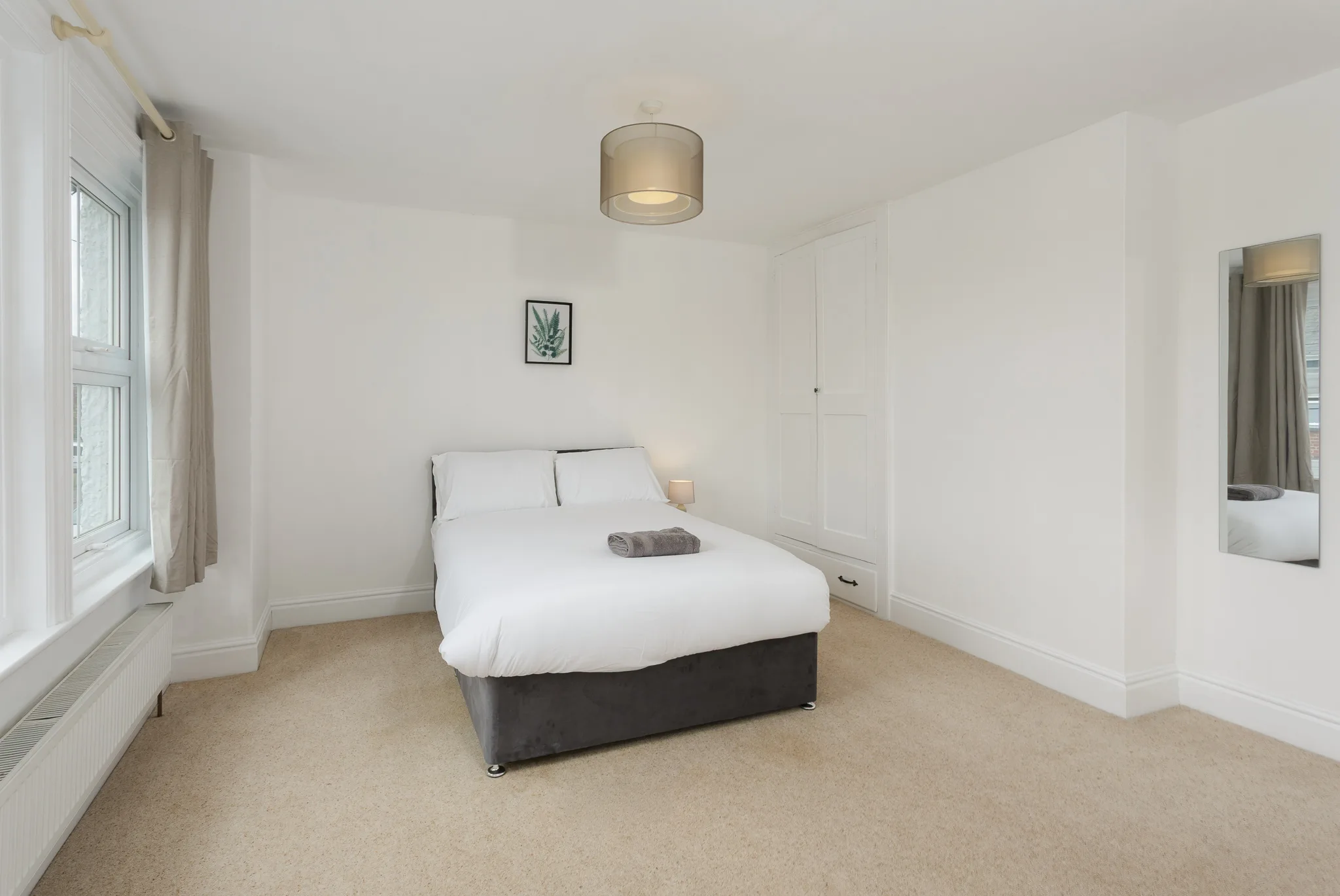 Modern minimalist bedroom with white walls and natural light