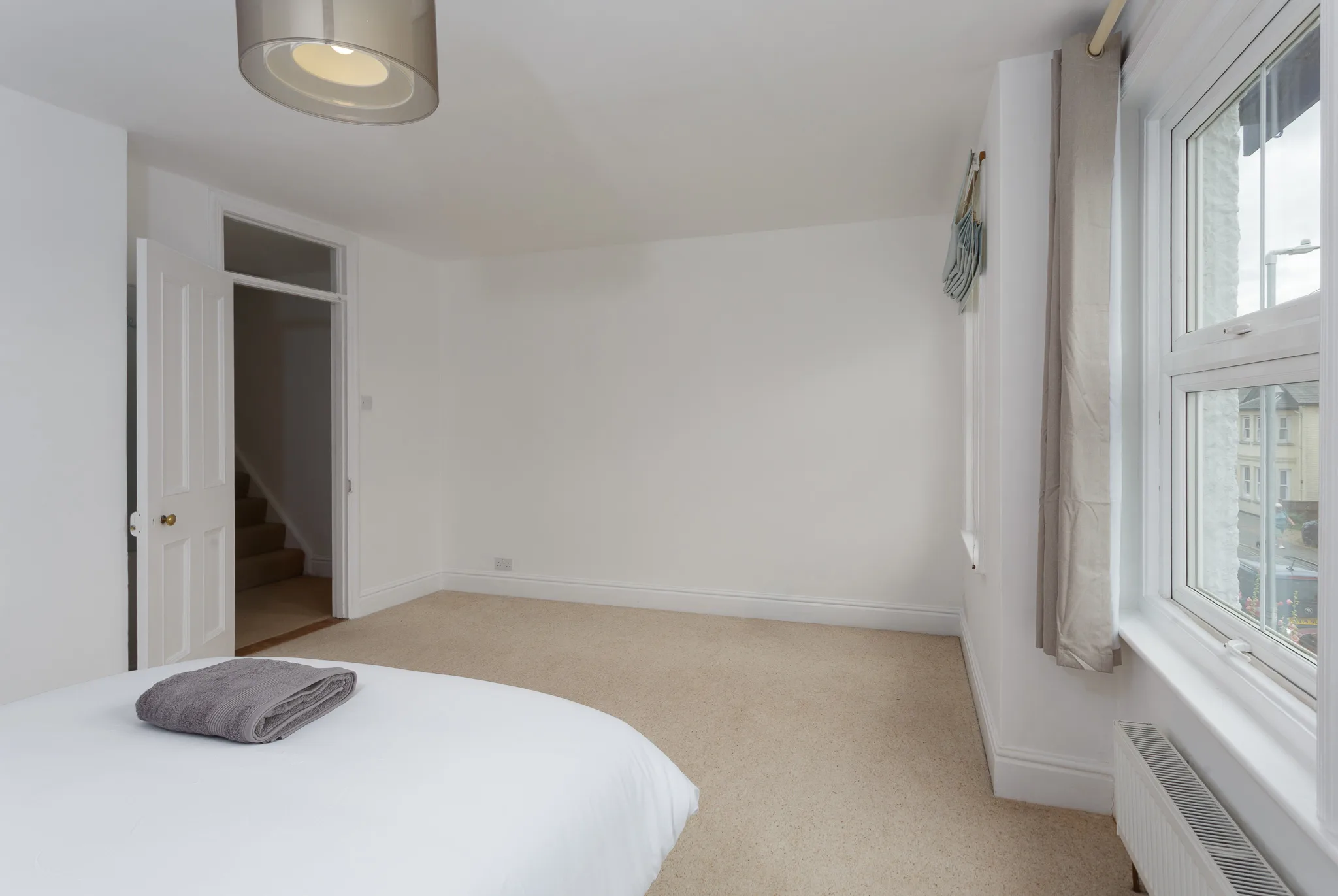 Bright, minimalist bedroom with white walls and natural light
