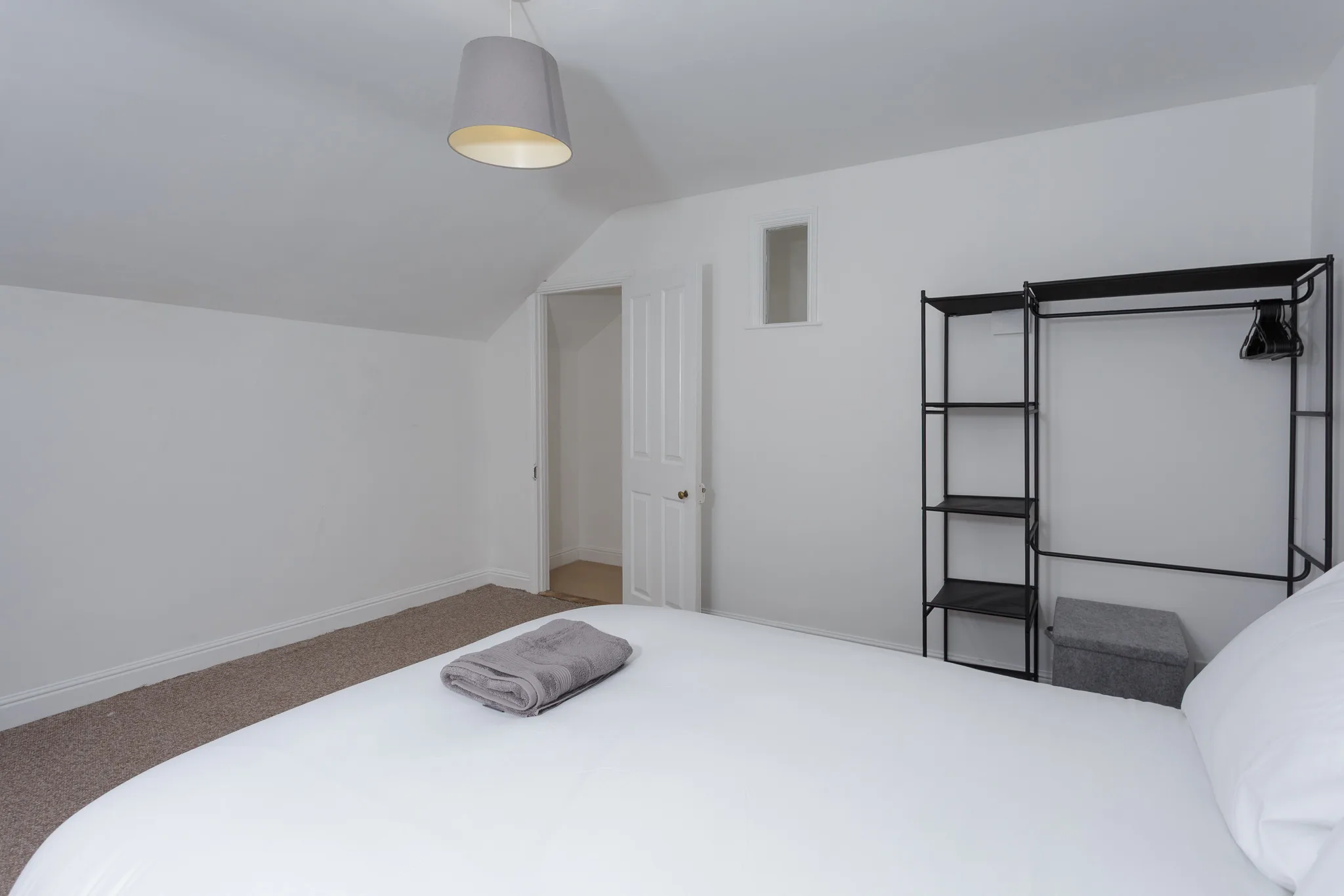 Modern minimalist bedroom with white walls and black metal wardrobe
