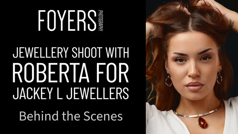 Woman wearing silver necklace with red pendant and hoop earrings against dark background. Text reads Foyers Photography - Jewellery Shoot with Roberta for Jackey L Jewellers - Behind the Scenes